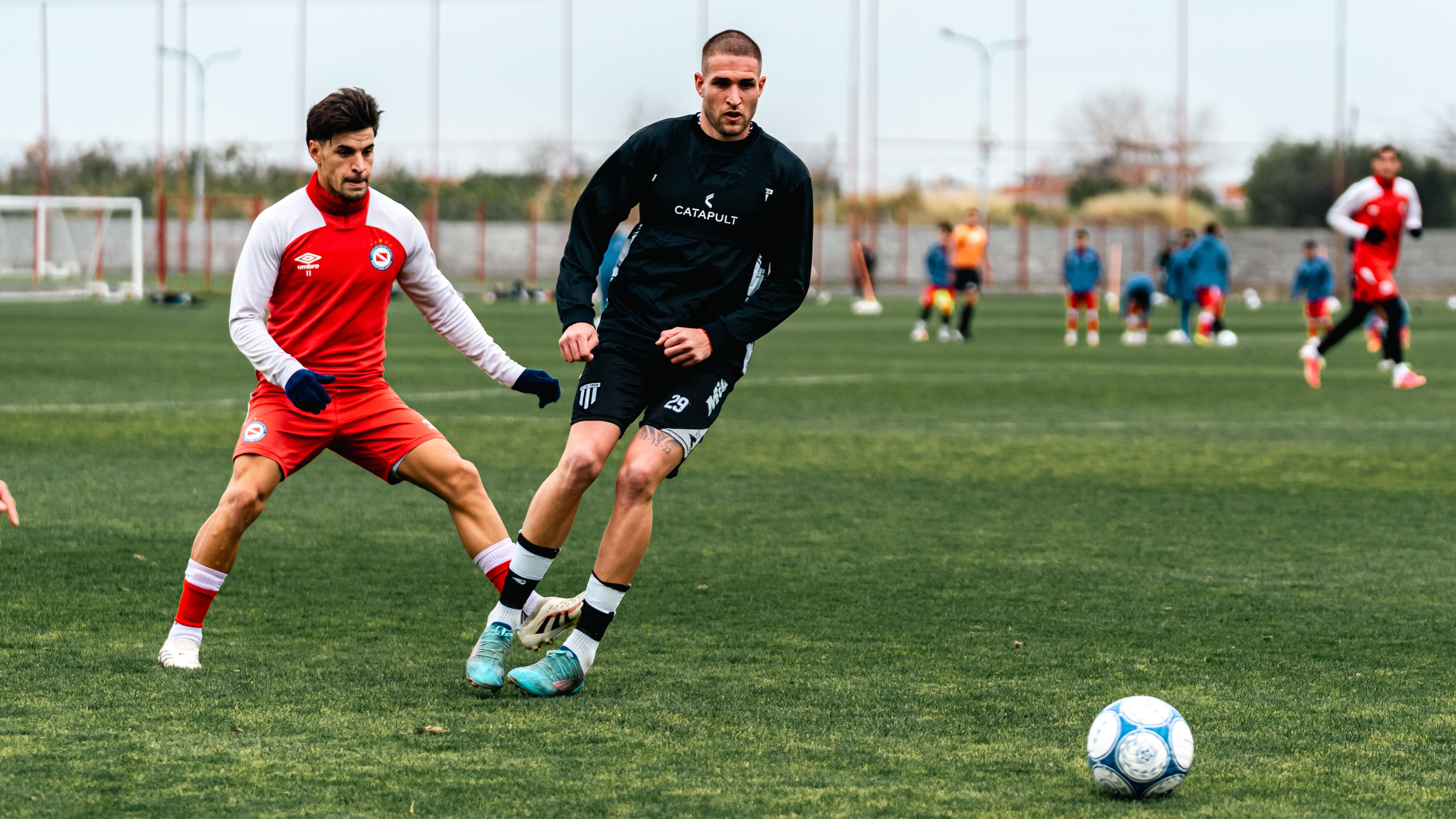 Two soccer players in action on the field during a match, showcasing athletic intensity and competition.