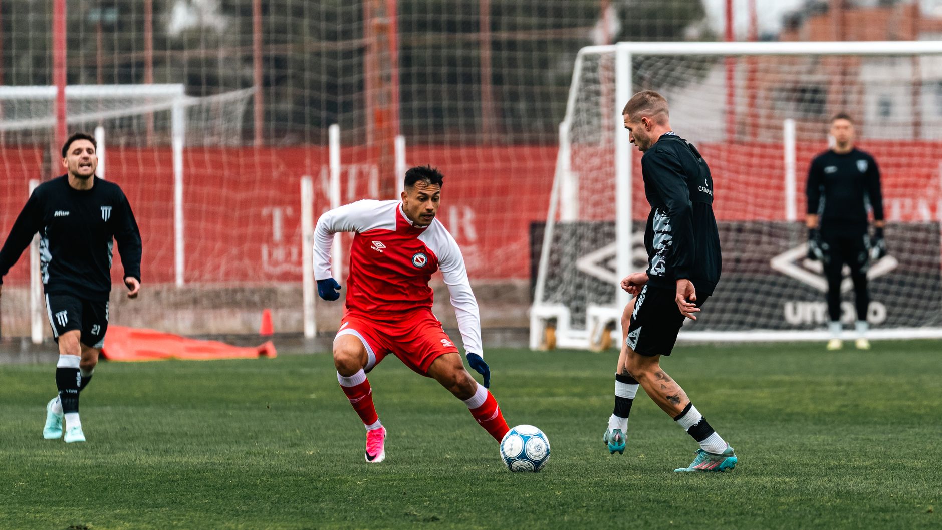 Soccer players competing on a green field with focus and intensity during a daylight match.