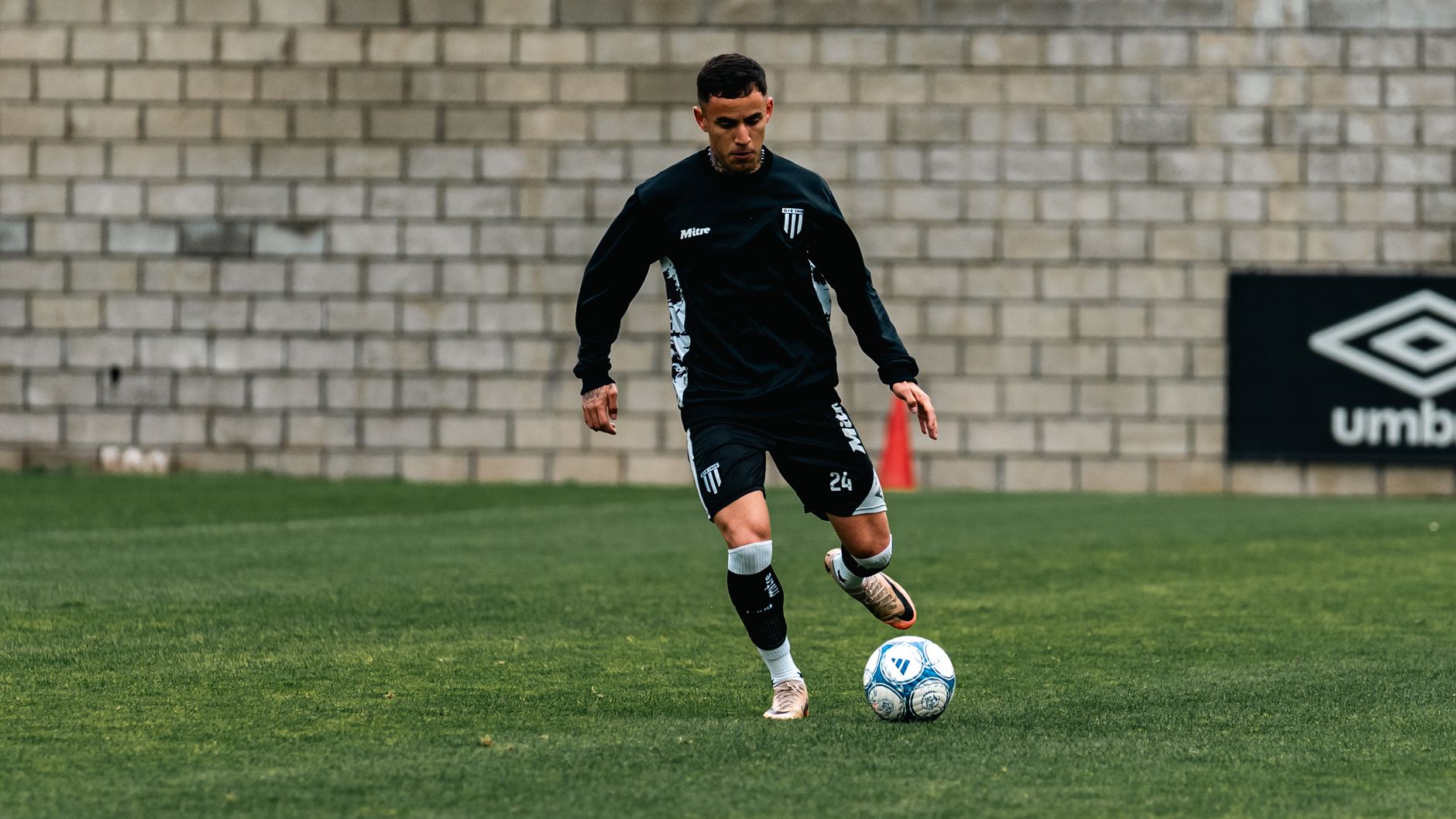 A midfielder cushioning a fast wall pass with the inside of the foot during an early morning training session