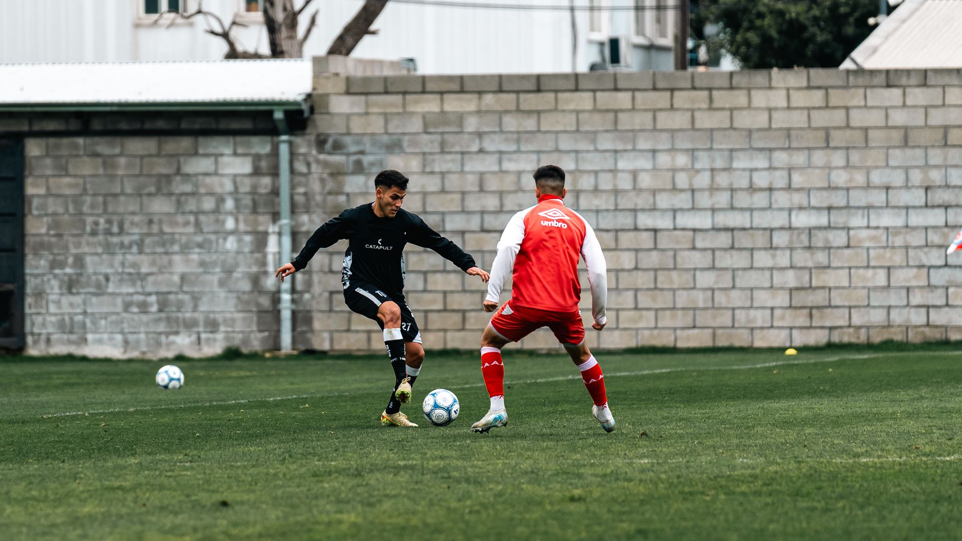 Two football players practicing a shoulder feint and explosive change of direction during an evening session