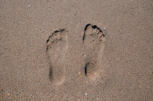 Foot Prints On Brown Sand