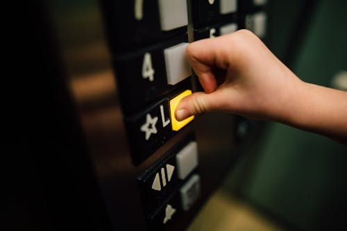 Free Anonymous person pressing button of lift Stock Photo