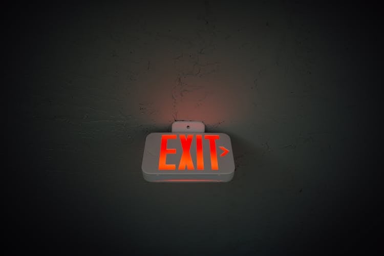 Exit Sign Hanging On Ceiling In Public Area