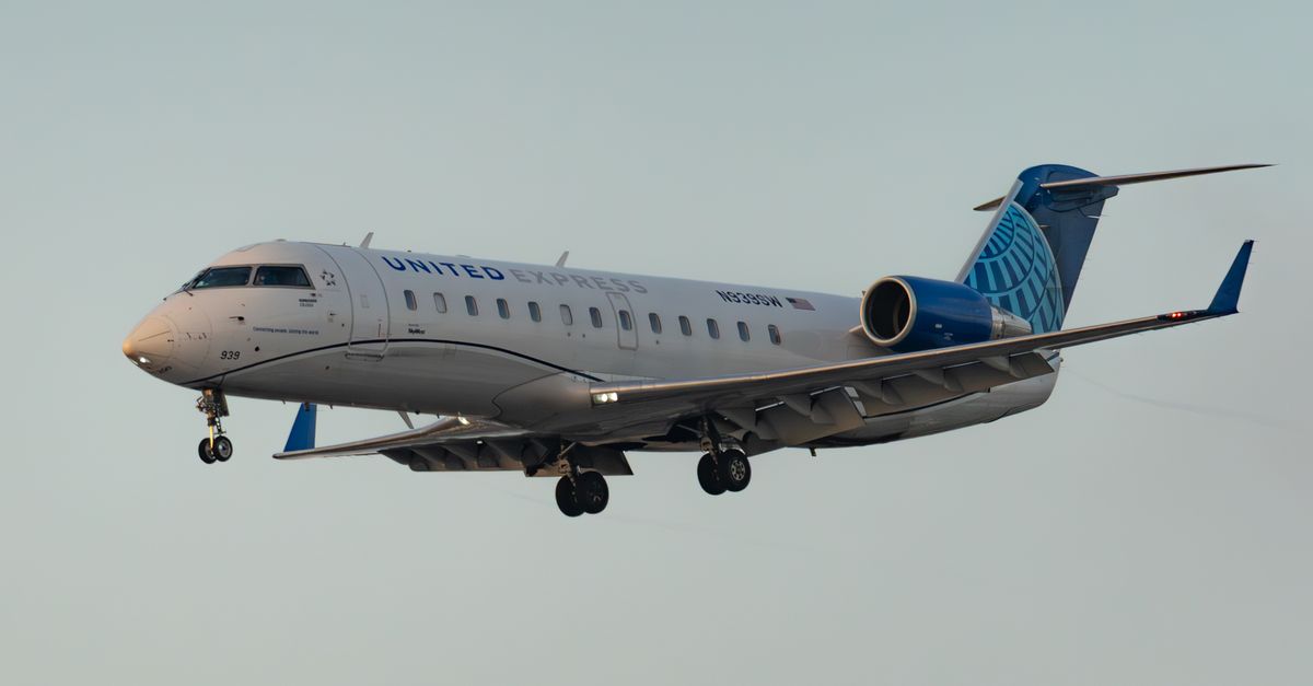 United Express jet captured flying against a clear sky, showcasing aviation in action.