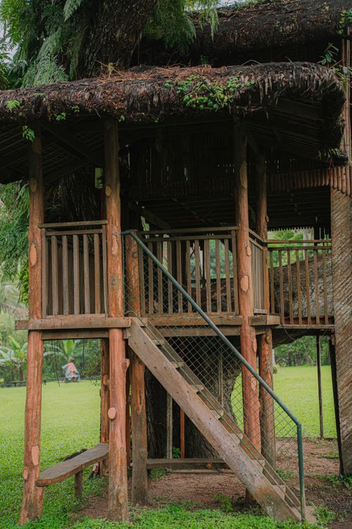 Free Charming wooden treehouse nestled in a green garden setting, perfect for outdoor adventures. Stock Photo