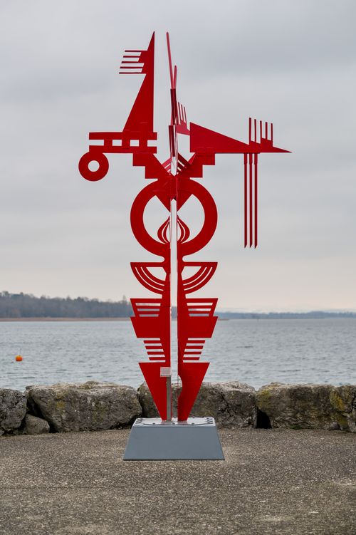 Free Bold red sculpture with geometric shapes by Lake Geneva under cloudy skies. Stock Photo