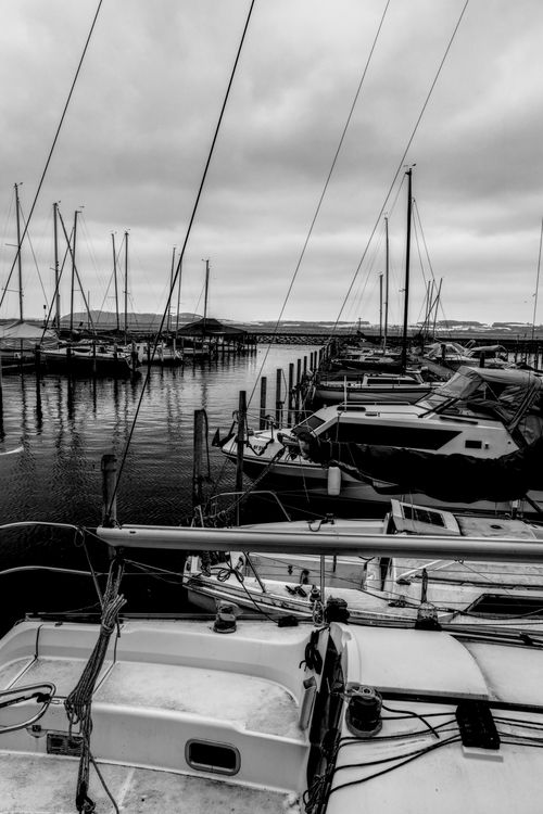 Free Peaceful marina with docked boats set against a cloudy sky. Stock Photo