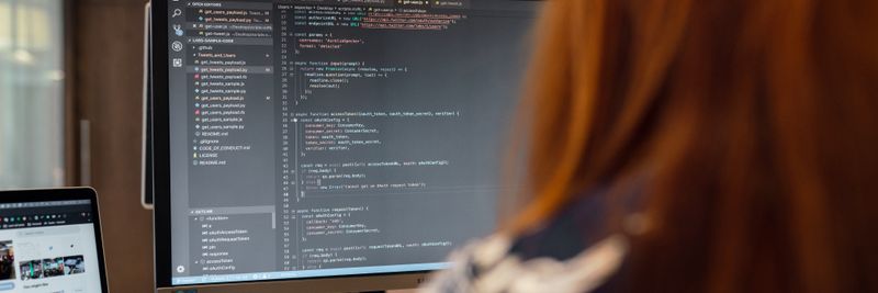 A female engineer works on code in a contemporary office setting, showcasing software development.