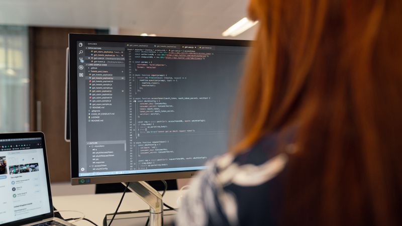 A female engineer works on code in a contemporary office setting, showcasing software development.
