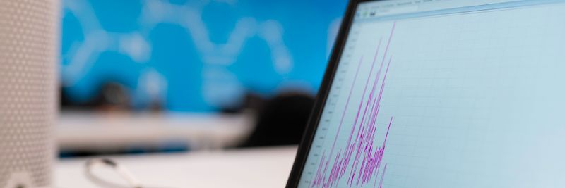 Laptop displaying data analytics graph in a modern office setting, symbolizing growth and technology.