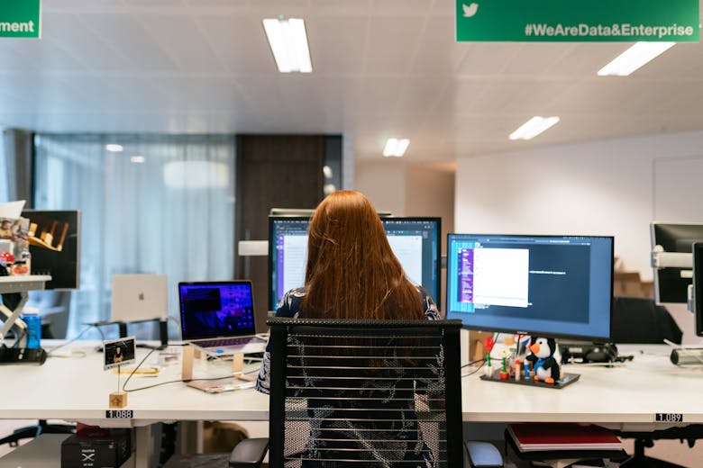 Multiple computer screens showing diverse data visualizations and code
