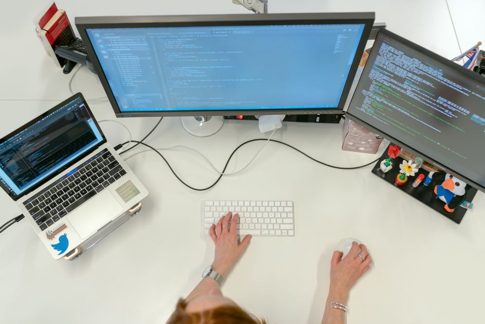 Video editor reviewing AI-generated transcript alongside Premiere Pro timeline in a professional editing suite