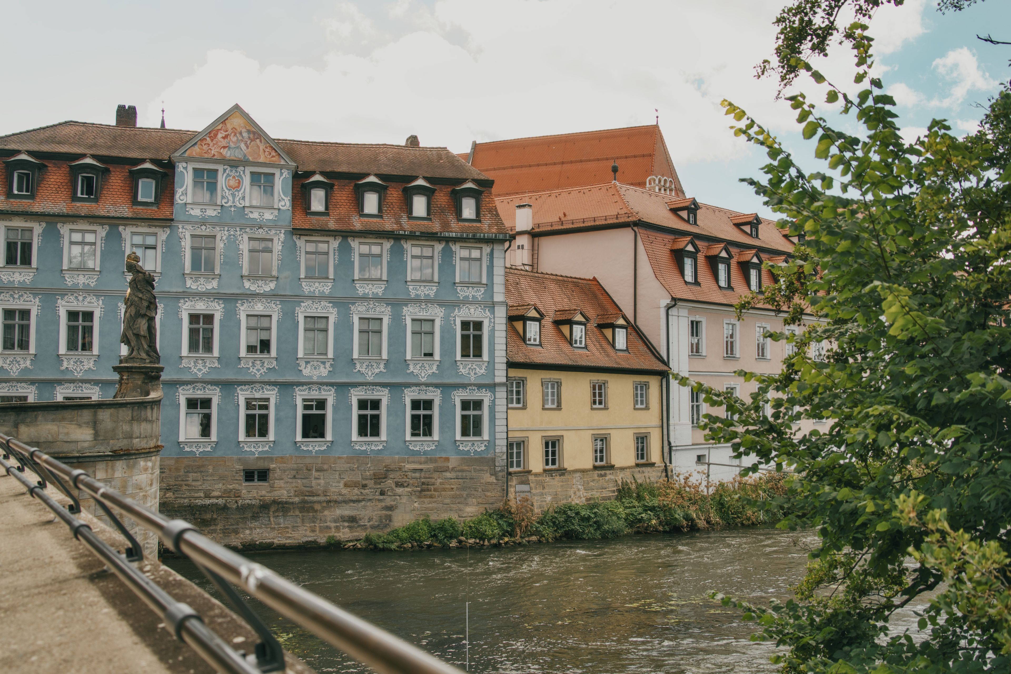 Charming old town architecture along a river in Germany, featuring colorful historic buildings.