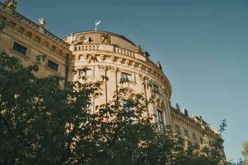 Free Sun-drenched facade of historic German architecture framed by lush greenery in old town. Stock Photo