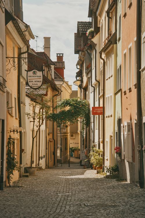 Free A picturesque cobblestone street lined with colorful historic buildings in a German old town. Stock Photo