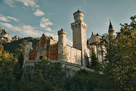 Stunning view of Neuschwanstein Castle surrounded by lush greenery and mountains.