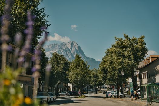 Charming street view in Germany with the Alps in the background, under a clear summer sky.
