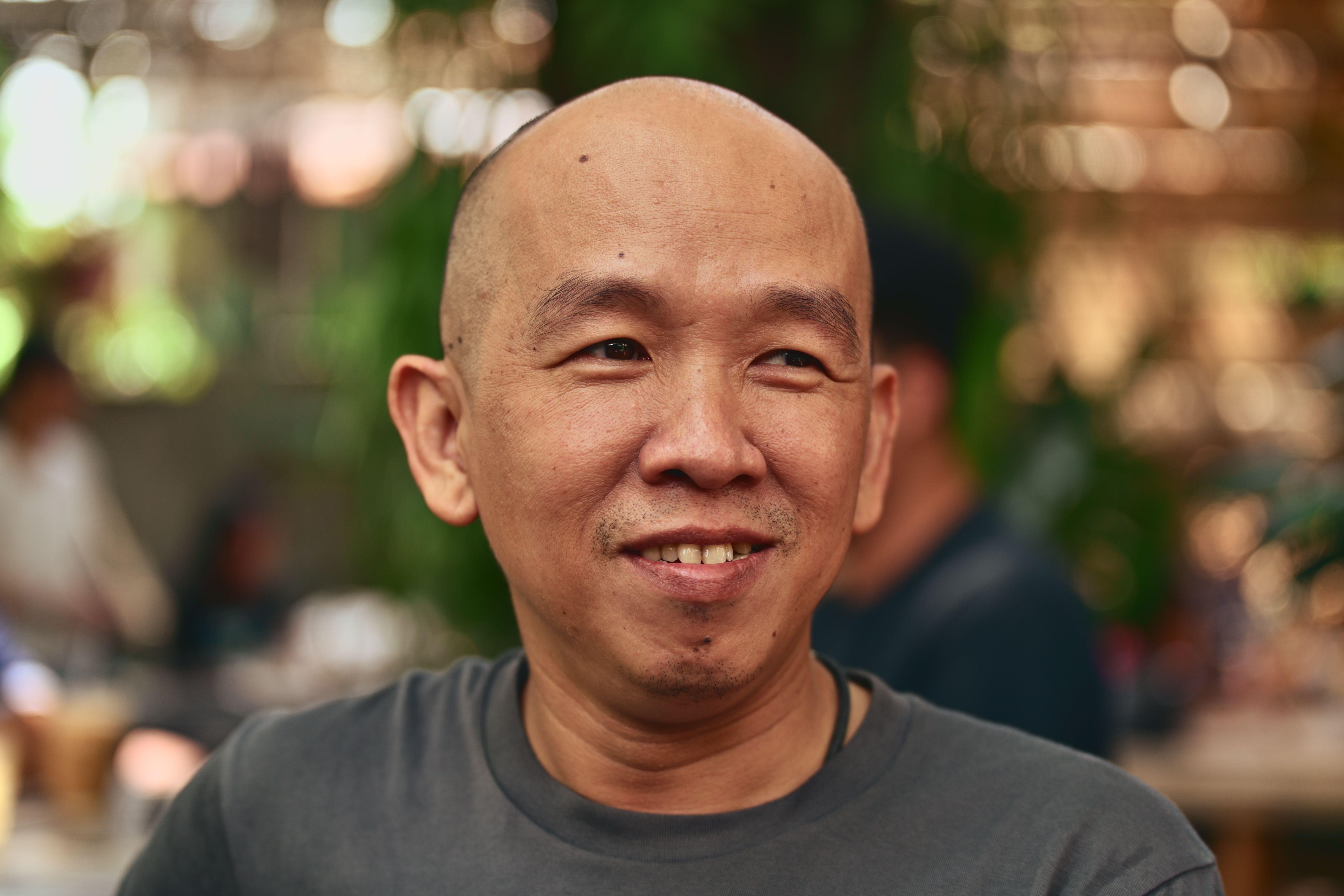 Smiling man enjoying a sunny day outdoors, exuding warmth and friendliness.