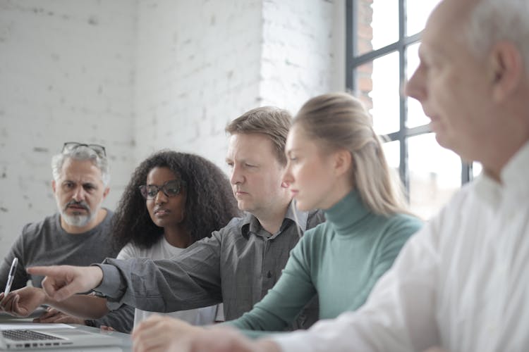 Concentrated Multiethnic Colleague Pointing At Laptop Screen At Conference