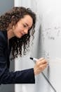 Woman Writing Formula on Whiteboard