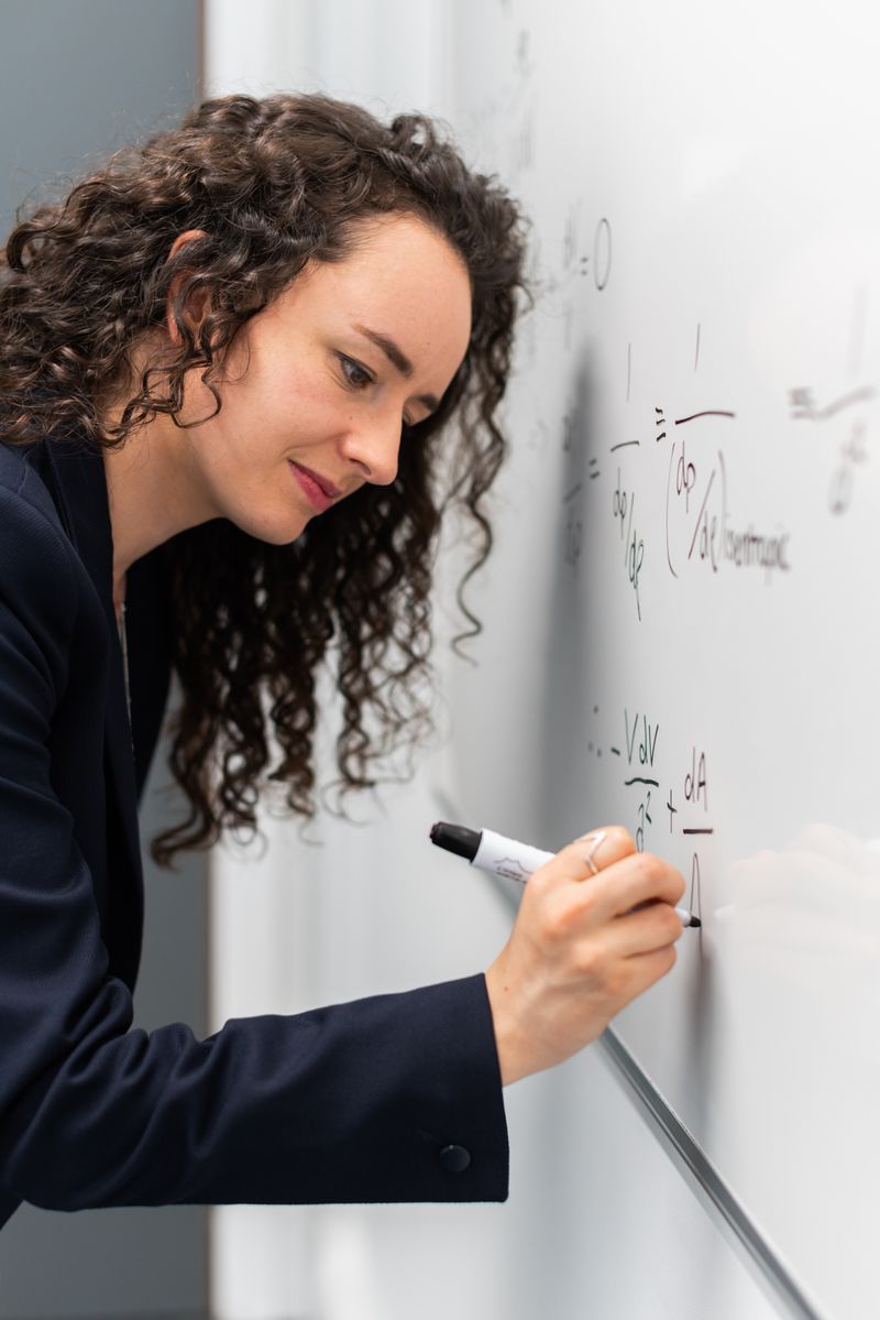 Writing a physics formula on a whiteboard