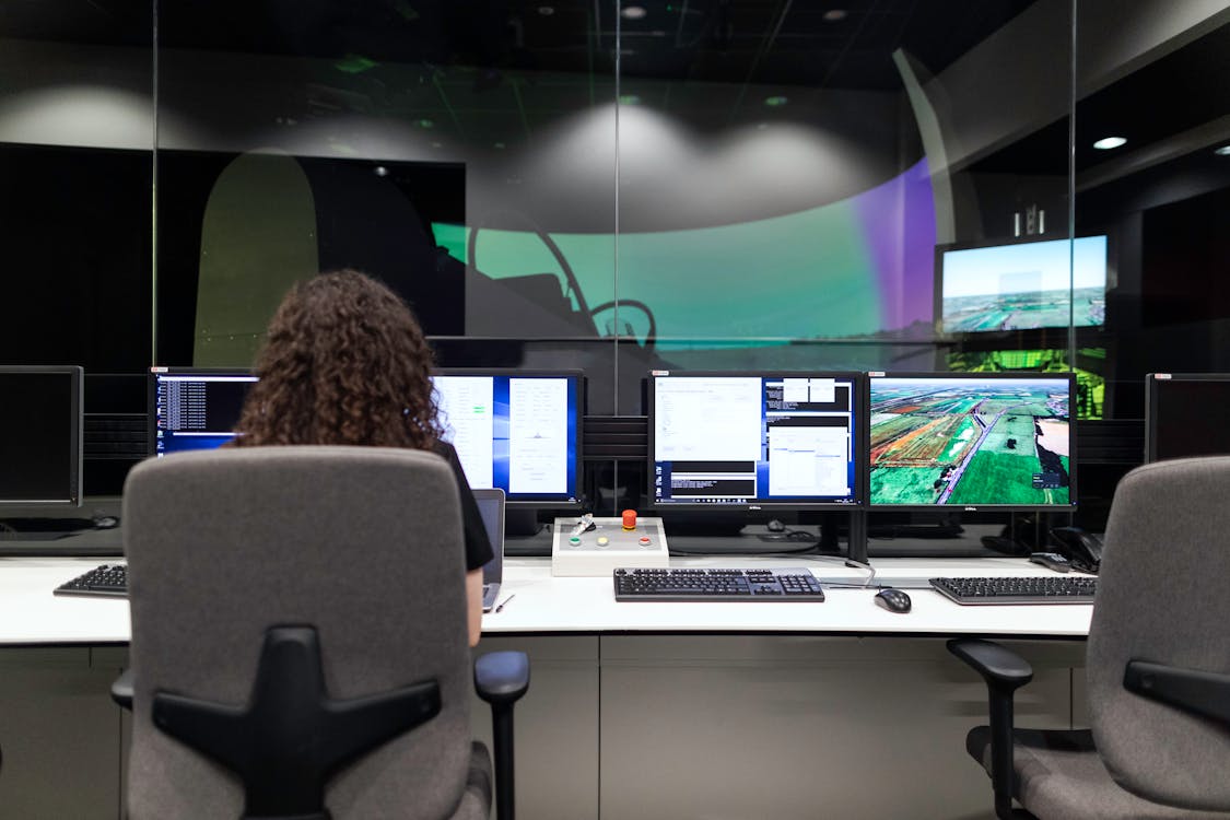 Free Female Engineer Controlling Flight Simulator Stock Photo