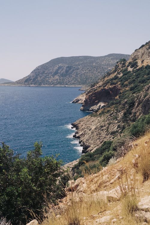 Free Explore a breathtaking coastline with rugged cliffs and deep blue sea under a bright sky. Stock Photo