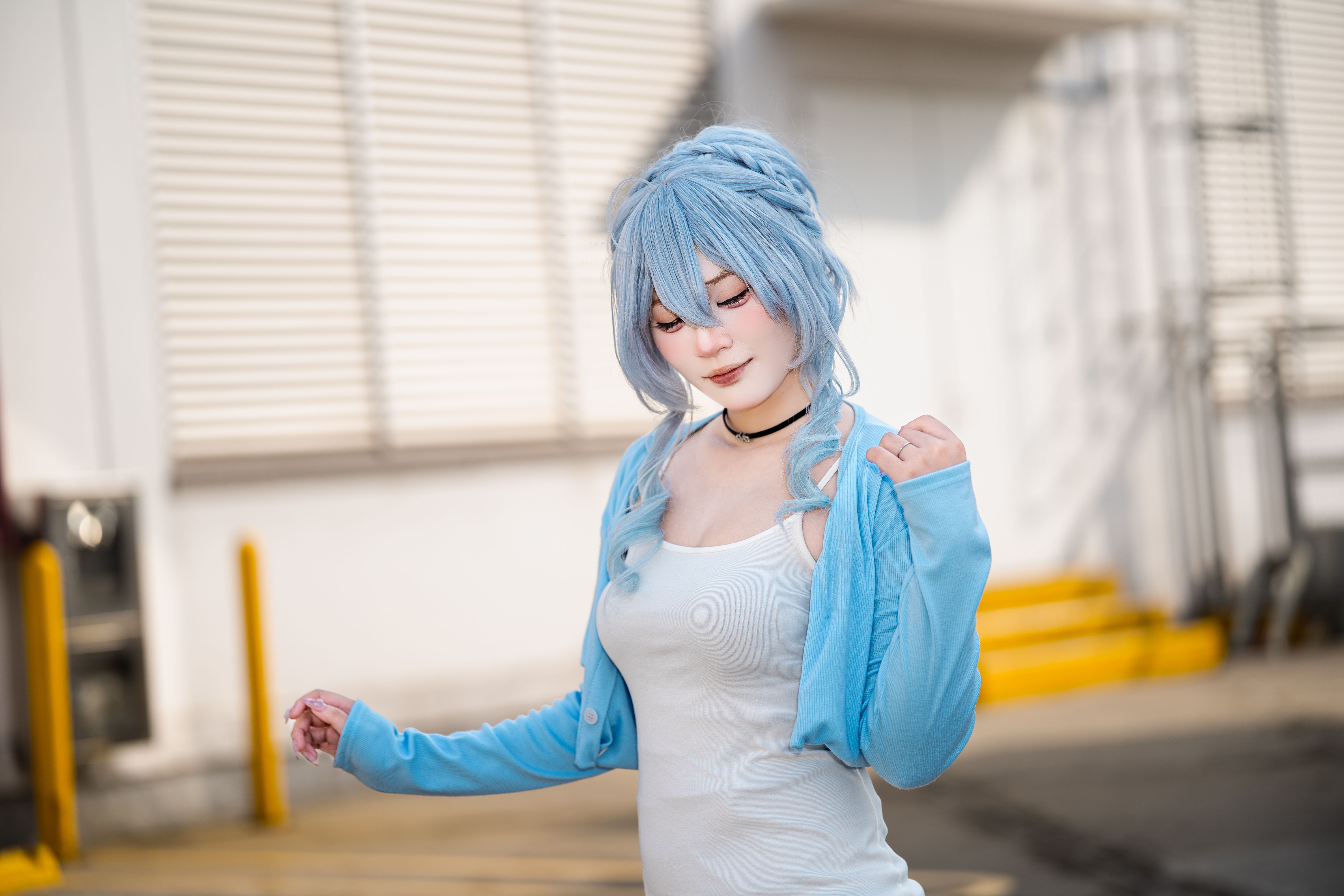 A vibrant outdoor shot of a cosplay enthusiast portraying a character with blue hair and a stylish outfit.