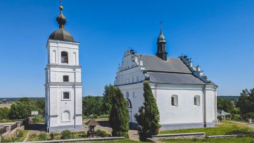 Free Beautiful white church and bell tower under clear blue sky, surrounded by greenery. Stock Photo