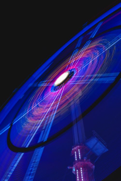 Free Colorful ferris wheel with vibrant lights spinning at night in Germany. Stock Photo