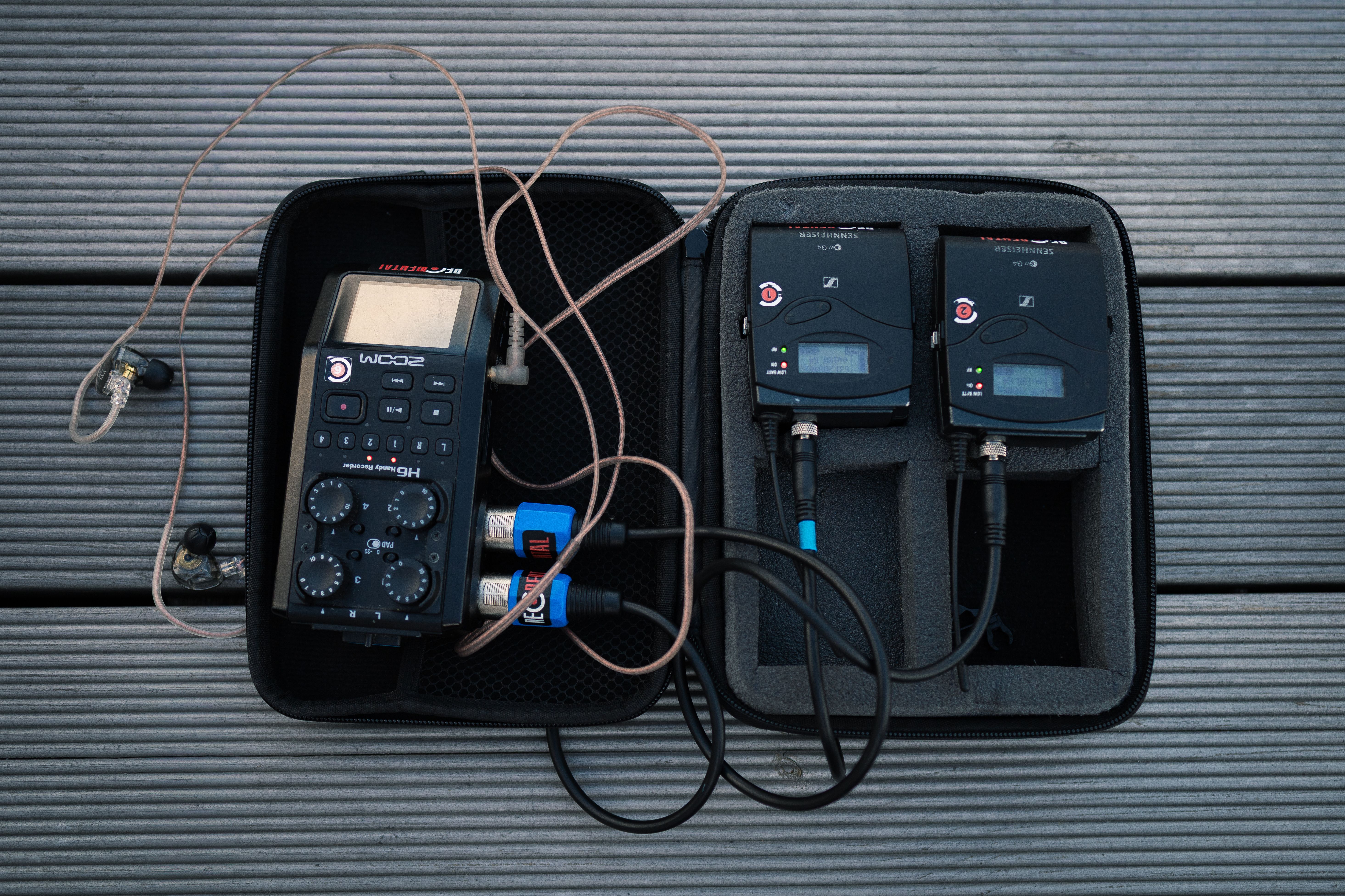 Audio recording gear, including a Zoom H6 recorder and wireless transmitters, displayed in a padded case.