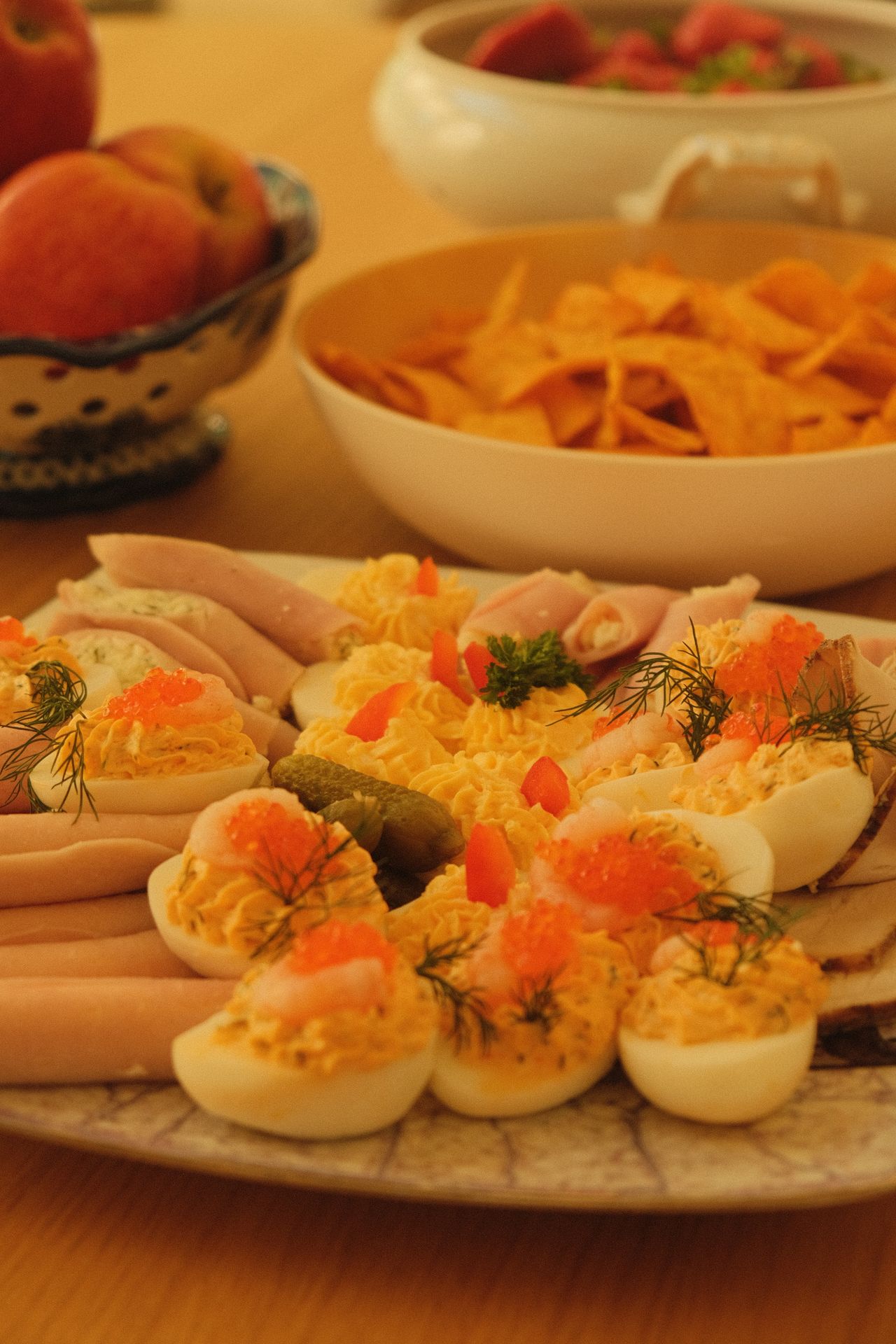 Appetizer spread with deviled eggs, ham, and dips