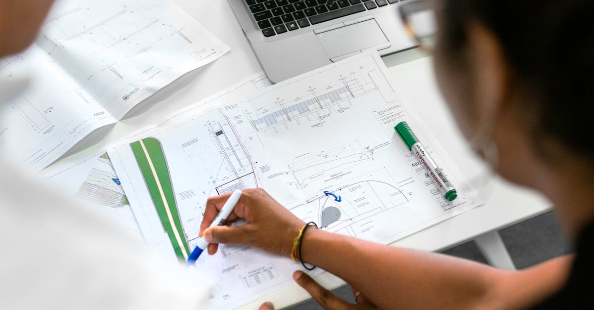 A person looking frustrated at a tangled mess of computer cables on a desk.