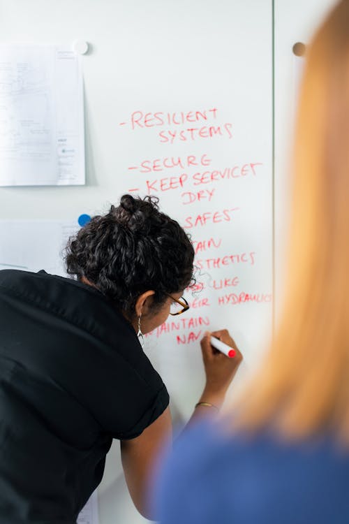 Female Engineer Writing on Whiteboard