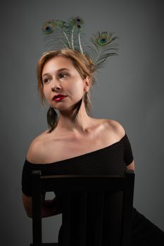 A stylish woman with peacock feathers in her hair, exuding elegance and grace.