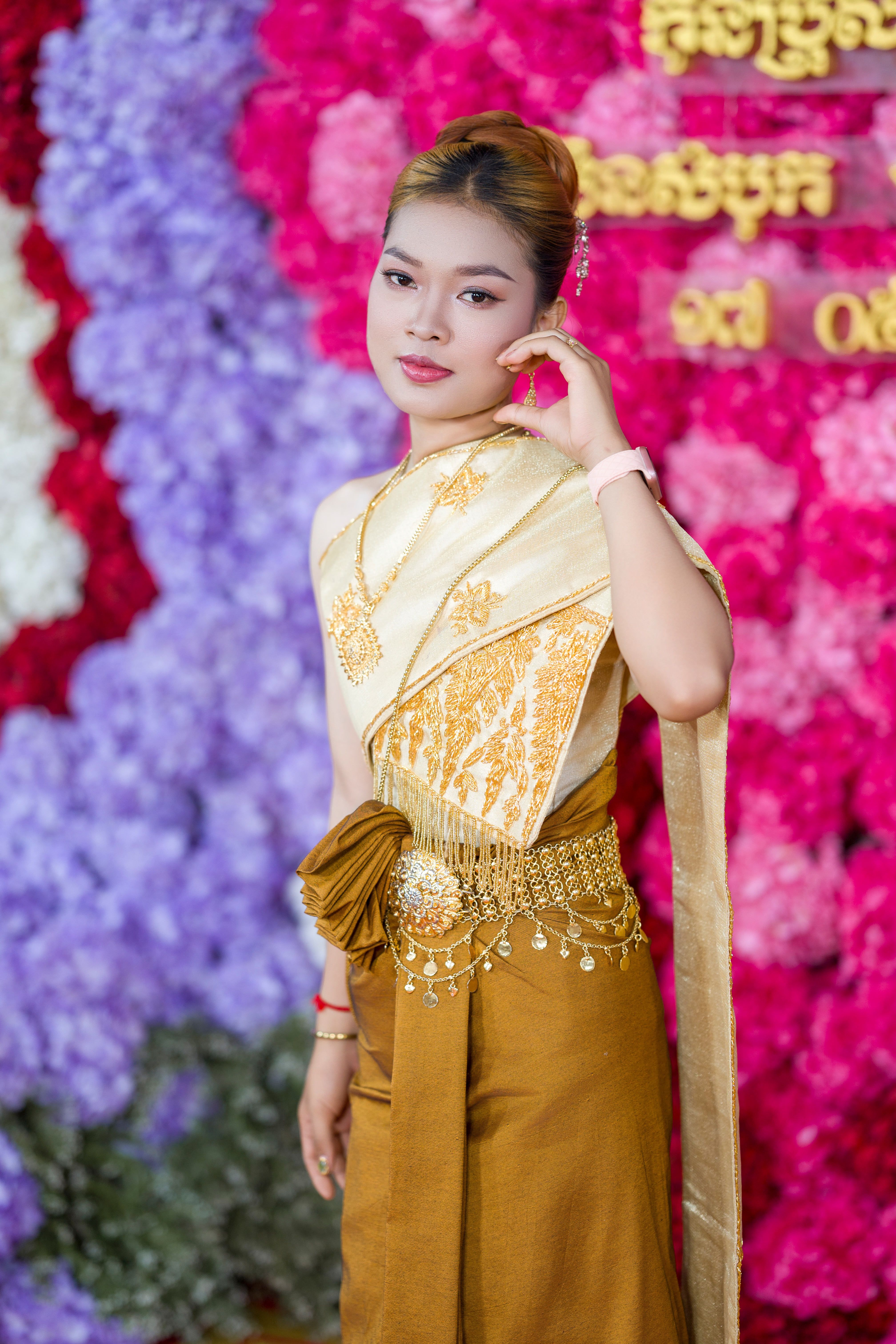 Elegant woman in traditional Cambodian dress at a vibrant cultural event.