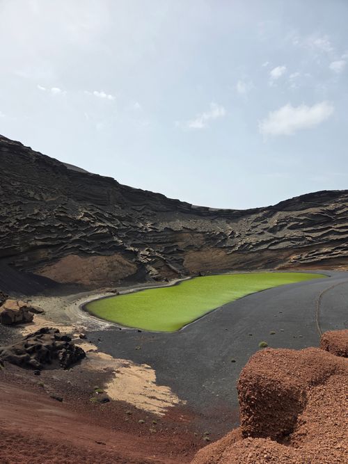Free Stunning view of El Golfo's green lagoon set against Lanzarote's volcanic terrain under a clear sky. Stock Photo