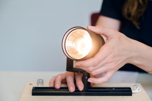 A female engineer testing a light fixture prototype in an office setting, showcasing innovation.