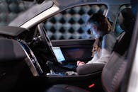 一个女人在隔离的房间里测试声音工程，她在车内用笔记本电脑工作