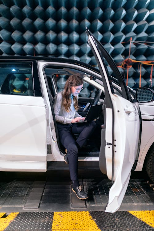 Female Engineer Sitting on a Car