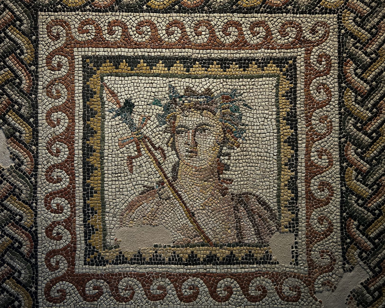 Ancient Roman mosaic depicting rooster fighting beside a crowded stone amphitheater