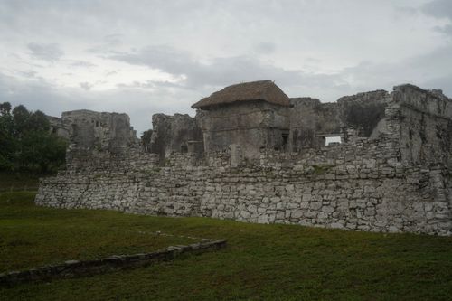 Free A stunning view of ancient stone ruins surrounded by lush greenery under a cloudy sky. Stock Photo