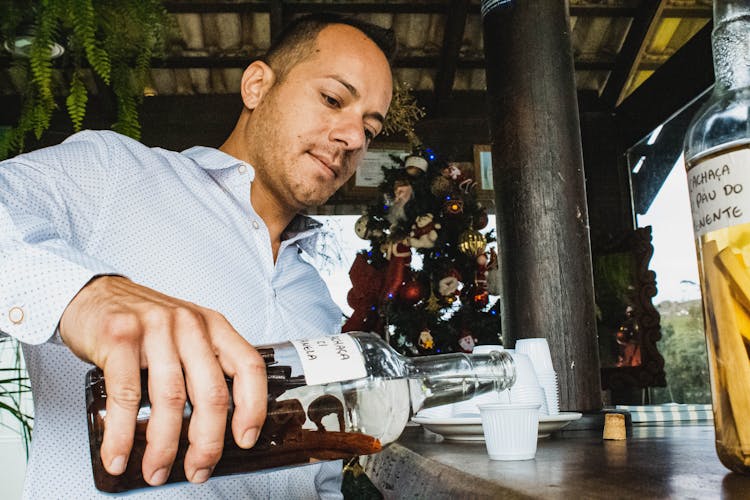 Man Pouring Rum In Shot In Bar