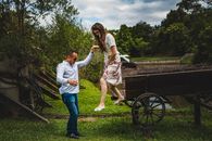 A Man Guiding a Woman while Stepping Down from the Wagon
