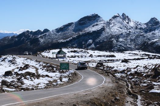 Breathtaking view of a winding road in a snowy mountainous landscape in Tawang, Arunachal Pradesh.