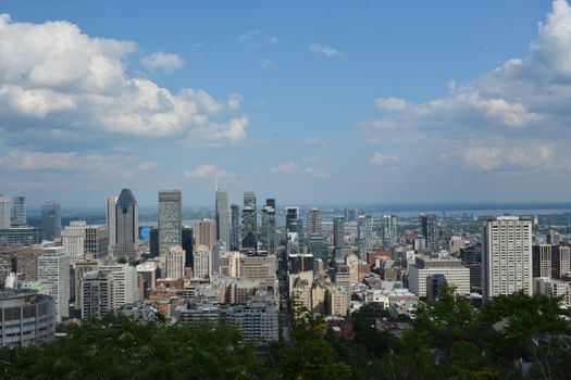 Stunning aerial view of downtown Montreal with skyscrapers under a blue sky and clouds.