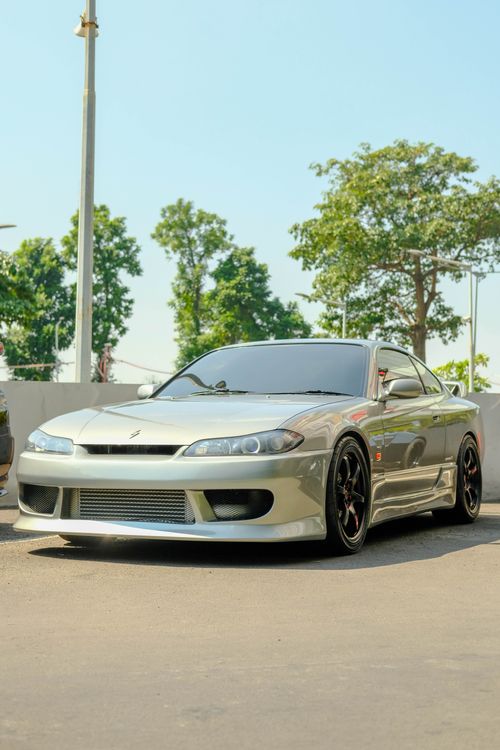 Free A stylish silver sports car parked outdoors, showcasing sleek design under bright daylight. Stock Photo