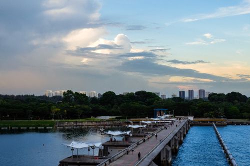 Free A scenic view of a jetty leading towards the skyline, set against a dramatic sky in Singapore. Stock Photo