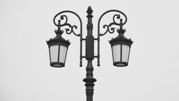 Black vintage street lamp post with ornate details and two lanterns in a classic style.
