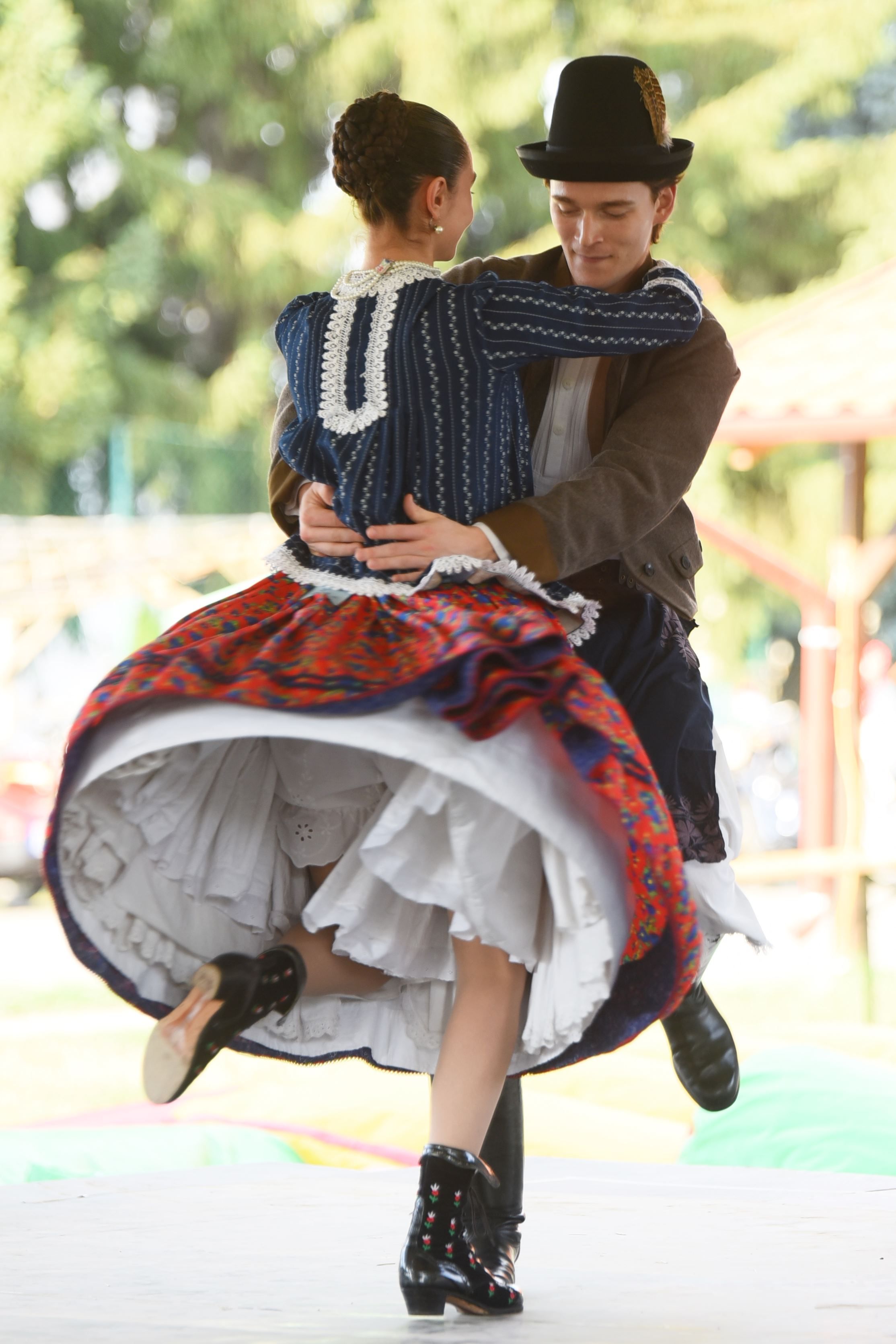 Vibrant Hungarian folk dancers performing outdoors in Panyola, showcasing traditional costumes.